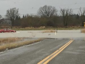 Barrett Road-Paradise Road car driving through with water over roadway