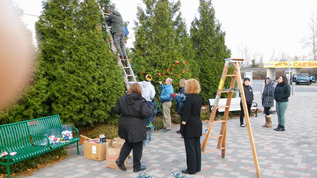 School district staff decorating one of the community holiday trees 2015-12-01