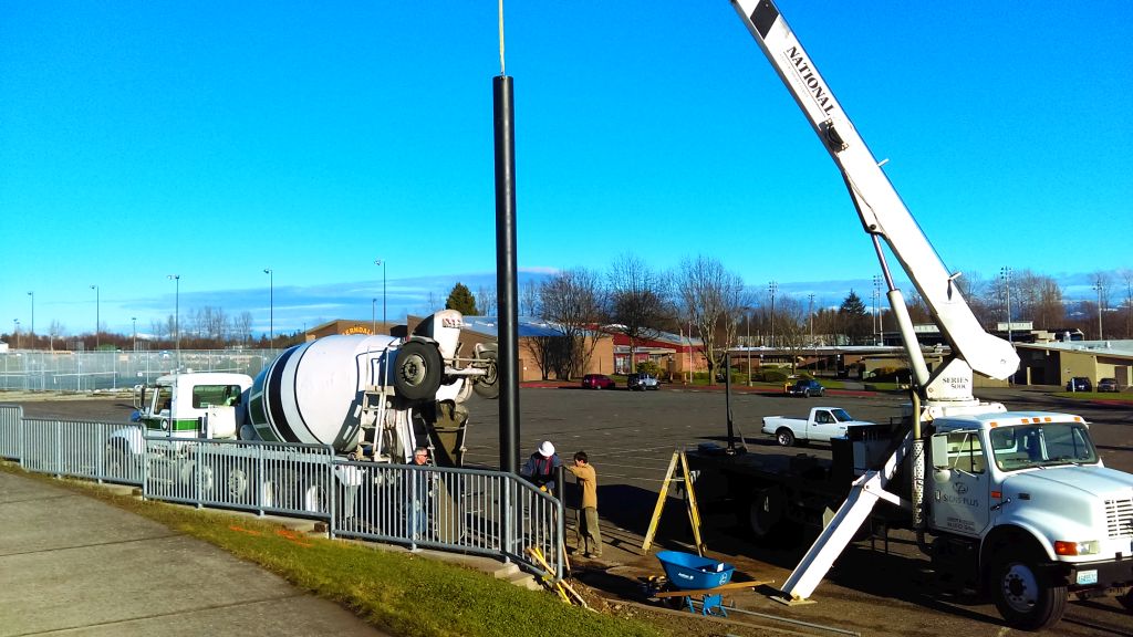 crews set support pole in place in FHS parking lot 2015-12-29