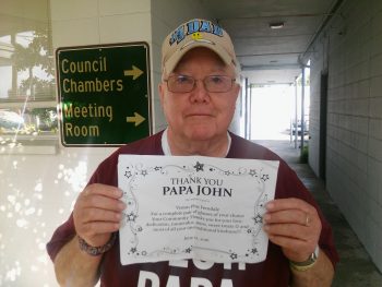 Papa John Robinson with his eye glasses certificate