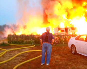 Bill Roeselle looks on as his storage building burns. Photo Dana Harkins