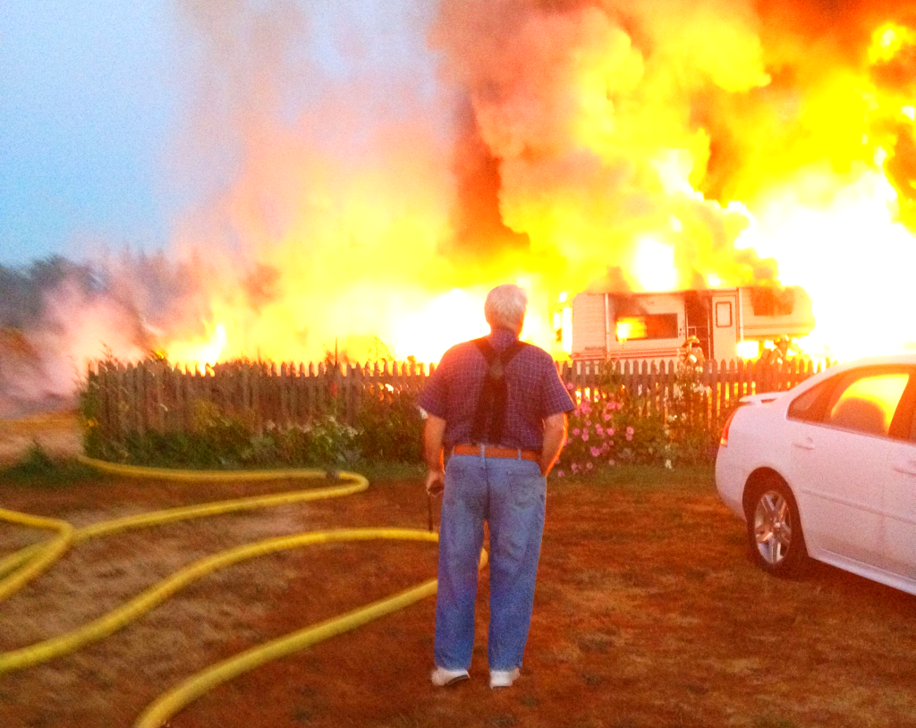 Bill Roeselle looks on as his storage building burns. Photo Dana Harkins