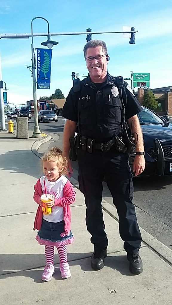 While investigating a crash on Main Street, Ferndale Police Officer Mike Catrain took time to pose with an admiring fan (September 25, 2016). Photo courtesy of Sarah Dalrymple.
