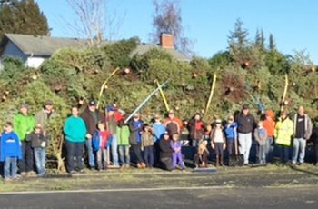 Cub Scouts and helpers pose in front of some of the trees picked up for disposal (January 2016). Photo courtesy Sharon Morey.