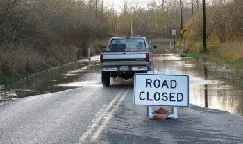 Vehicle driving around a road closed sign on Marine Drive during flooding (November 6, 2016). Photo: Whatcom News