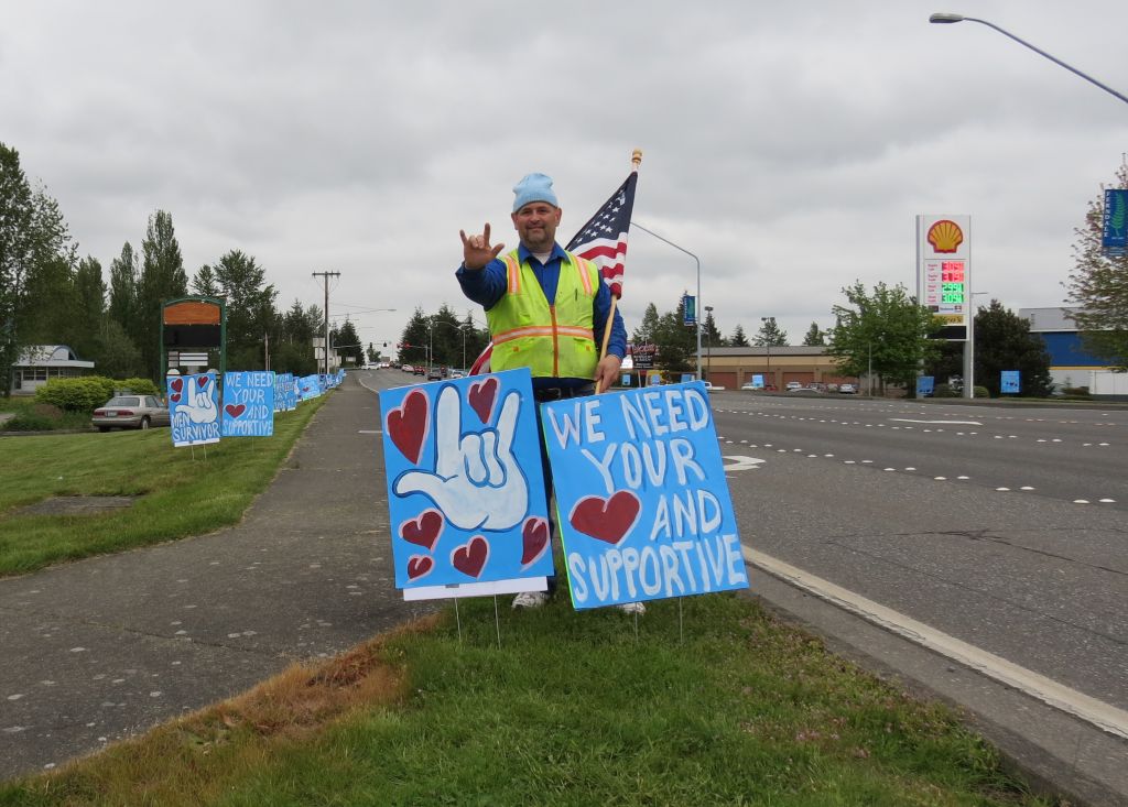 michael thompson stands alongside main street with some of his signs 2017-05-17