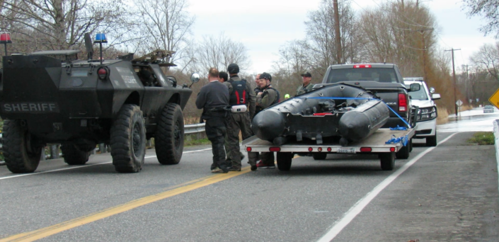 WCSO armored personnel vehicle  alongside SAR watercraft as both prepared to effect a rescue of a motorist stranded in floodwaters behind "Road Closed" signs on Ferndale Road (November 24, 2017). Photo: My Ferndale News