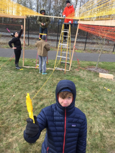 volunteers work to build temporary art - The Orange Tunnels - in Griffintown Park