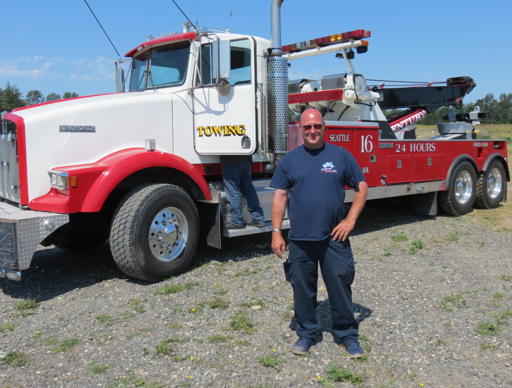 Heston Hauling owner Chris Heston poses in front of the latest addition to his company's truck fleet 2018-06-19