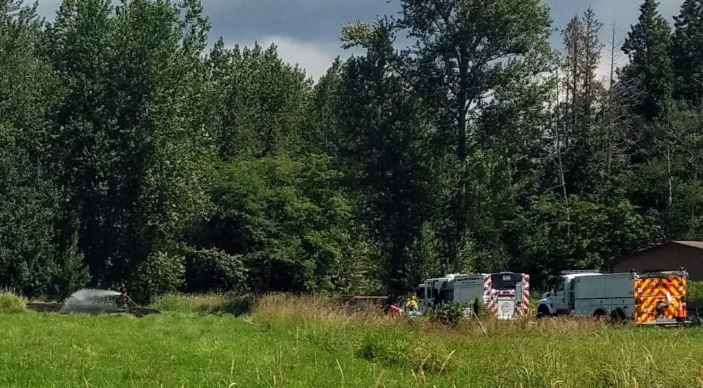 Firefighters wrap up knocking down a grass fire on Mountain View Road that had made its way into a nearby wooded area (June 23, 2018). Photo: My Ferndale News