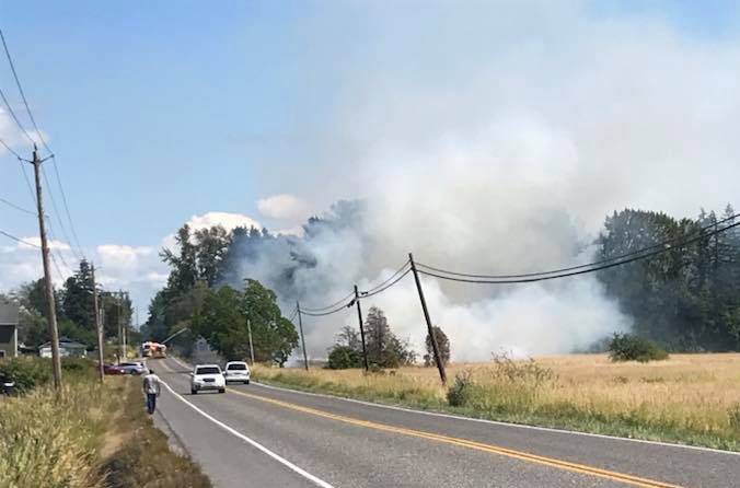 Firefighters are seen putting water one of several grass fires along Bay Road (July 20, 2018). Photo courtesy of Mandy Schuett