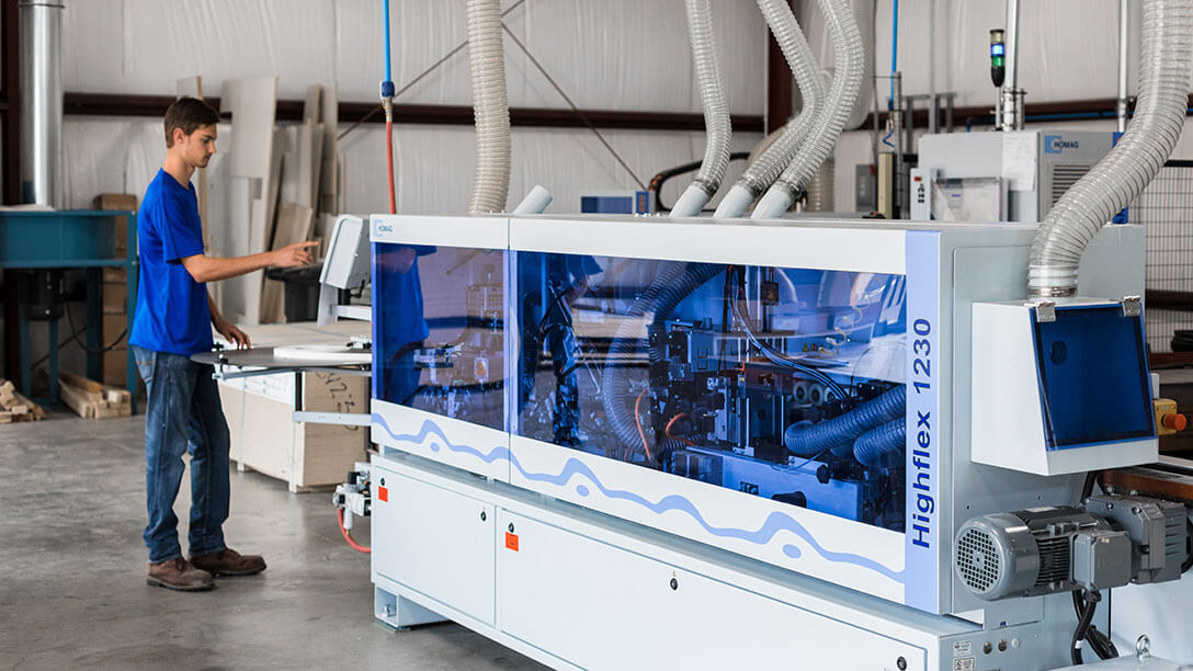 HighCraft employee operates edgebanding machinery