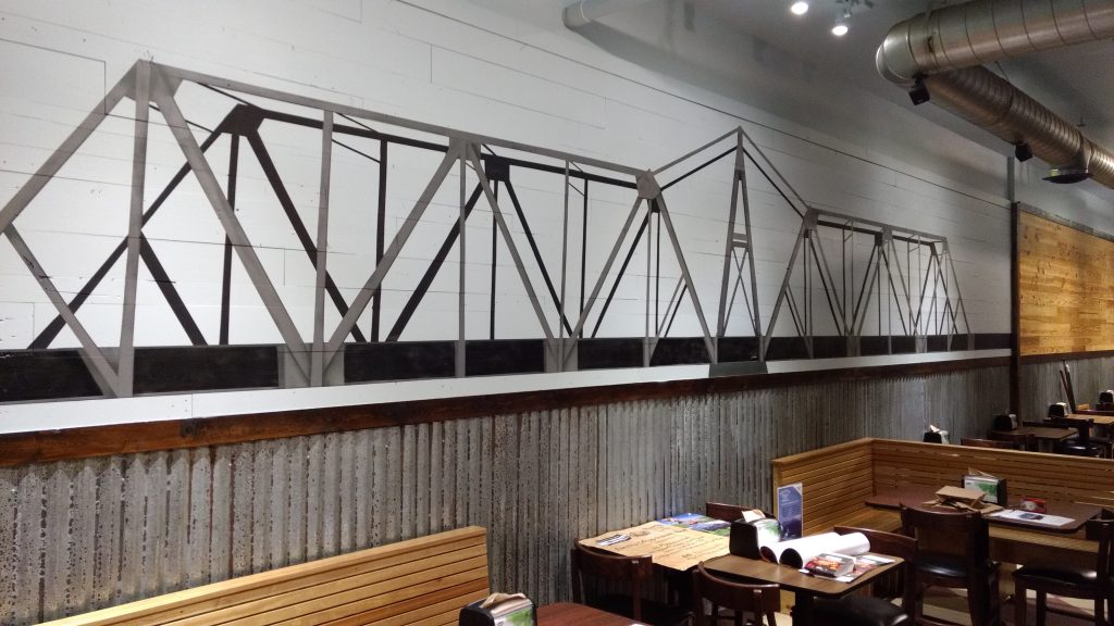 Mural of a railroad truss bridge inside Eagle's Roost restaurant