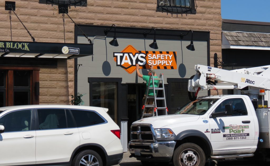 Sign Post workers install a new business' sign on 2nd Avenue (July 22, 2019). Photo: My Ferndale News