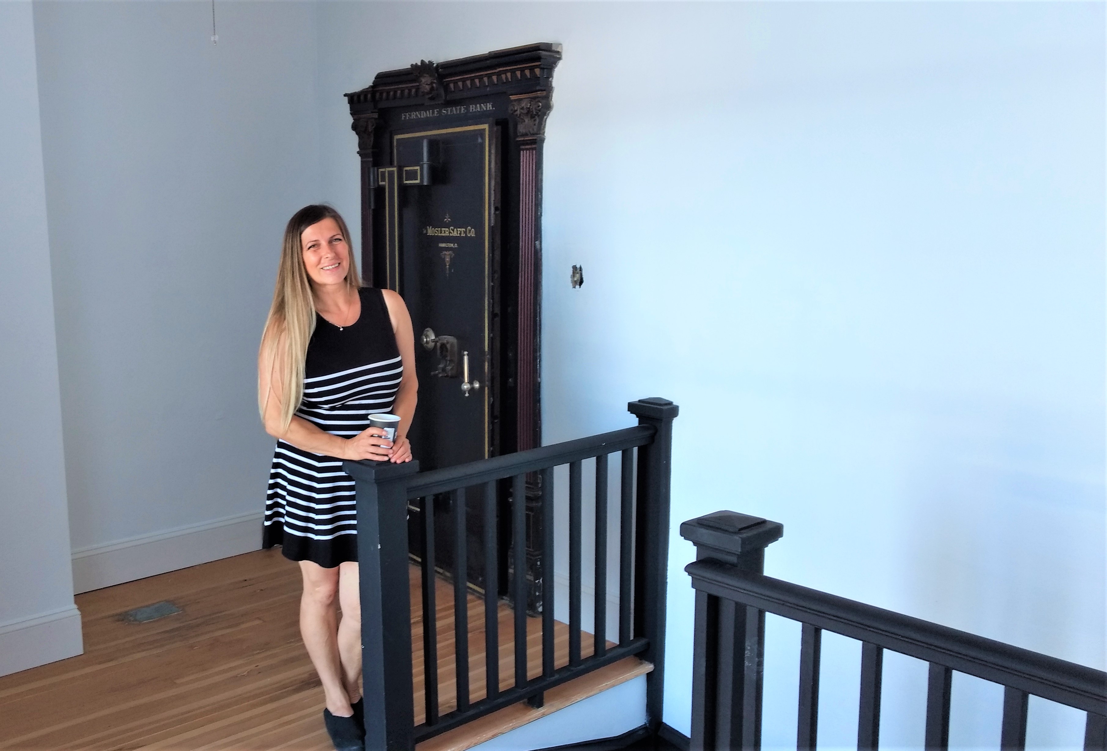 Owner Simona Nicolau poses next to the original Ferndale State Bank vault door inside Vine Creative Spaces Studio (July 25, 2019). Photo: My Ferndale News