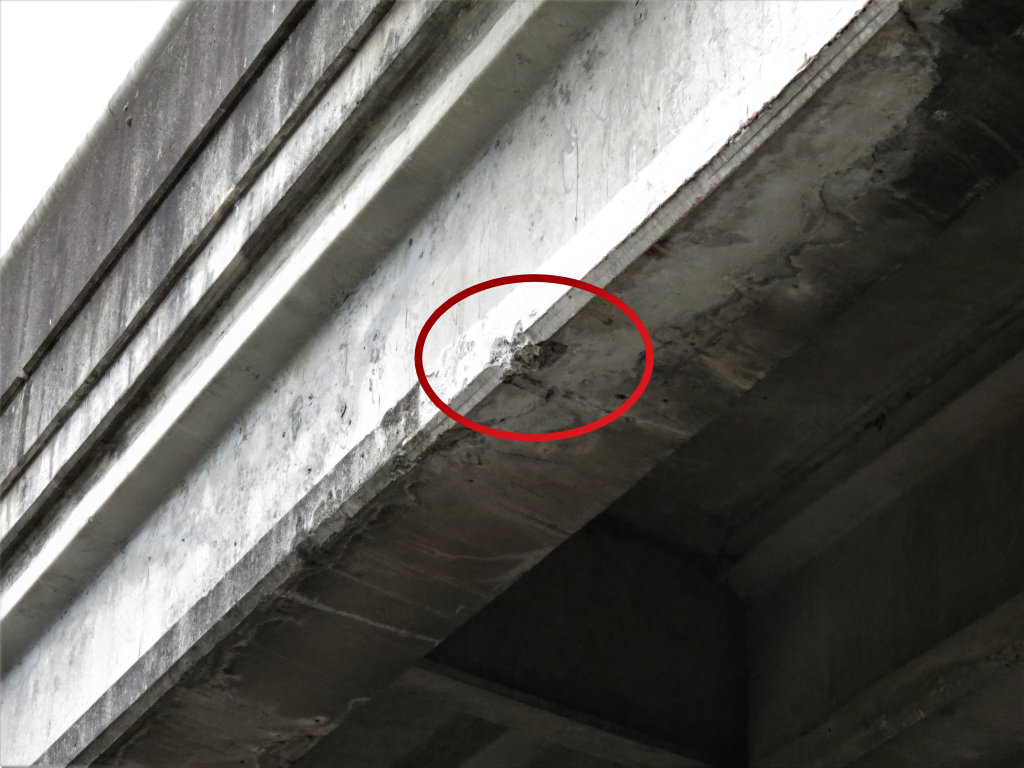 Damage visible on the I-5 overpass at Portal Way after a semi truck hauling a backhoe that struck it (August 17, 2019). Photo: My Ferndale News