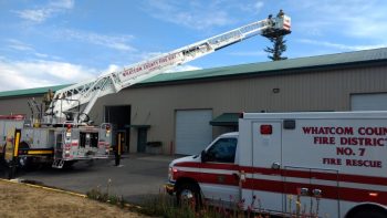 WCFD7 Ladder 46 personnel kept watch on the roof of a building in the Grandview Business Park while firefighters worked inside to tackle a fire (September 5, 2019). Photo: My Ferndale News