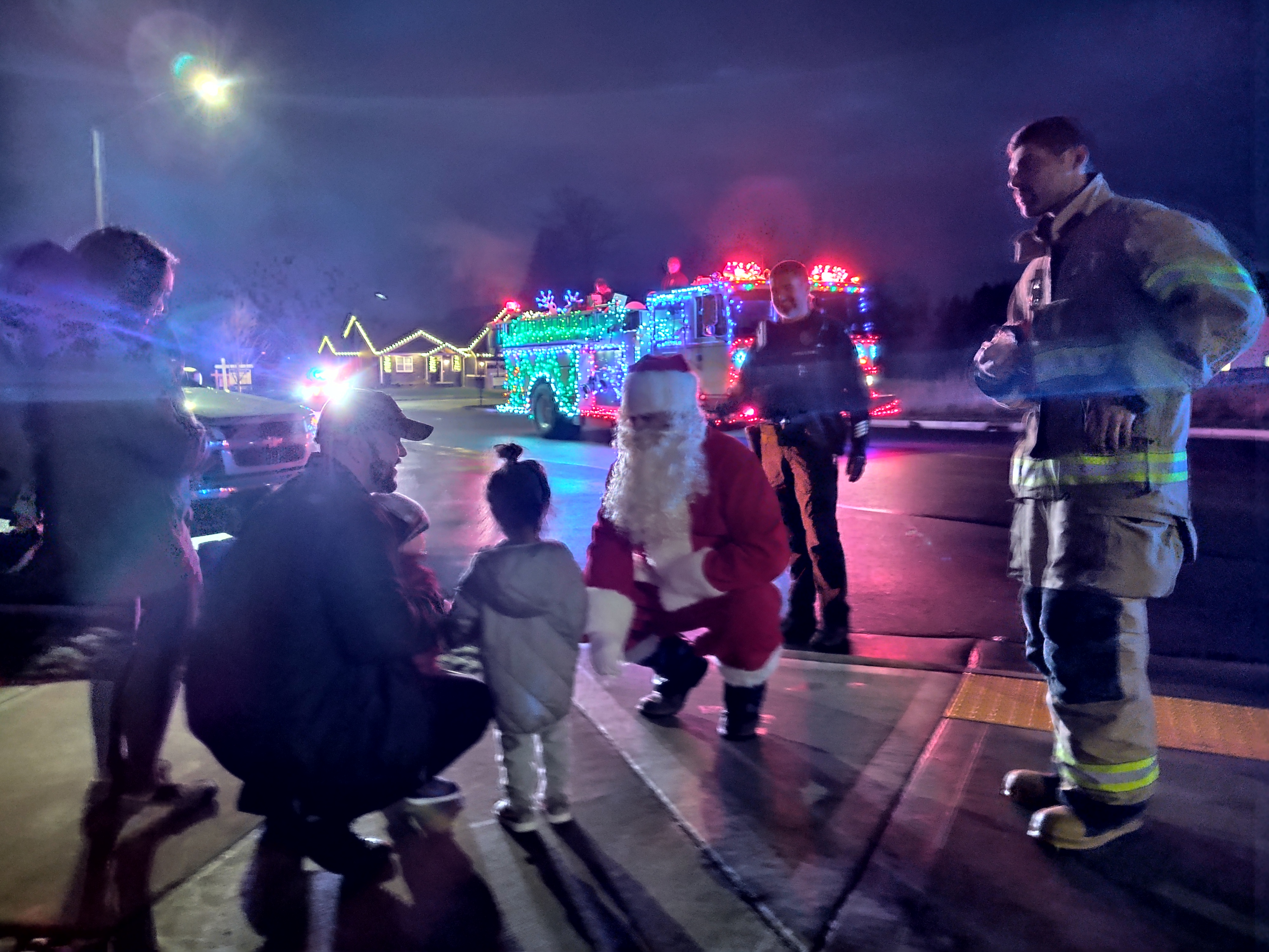 Santa talks with a family while Whatcom 7 Firefighter and Ferndale Police personnel look on during the annual Santa Food Drive (December 14, 2019). Photo: My Ferndale News