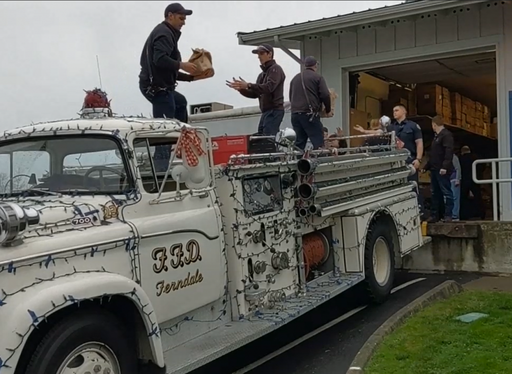 Whatcom 7 Firefighters unload one of several trucks needed to haul over 6,600 pound of community donations received during the Santa Food Drive to the Ferndale Food Bank (December 18, 2019). Photo: My Ferndale News