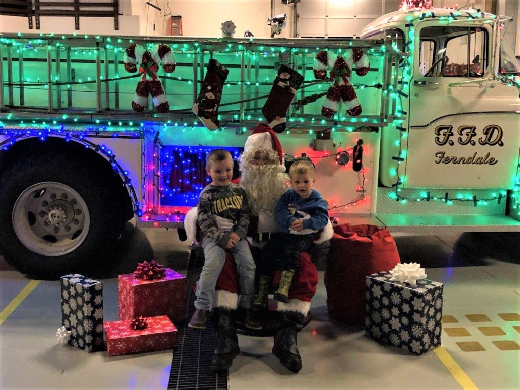Santa poses with a couple visitors at the Washington Street Fire Station (December 6, 2019). Photo courtesy of WCFD7