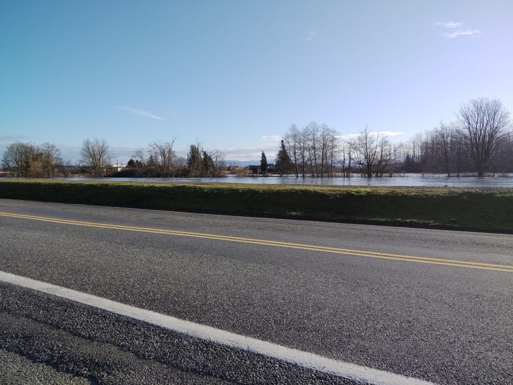 Looking east across Ferndale Road (near Cherry Street) and the Nooksack River as the river was flowing at just below 21 feet. Hovander Homestead Park is flooded in the distance (February 2, 2020). Photo: Whatcom News