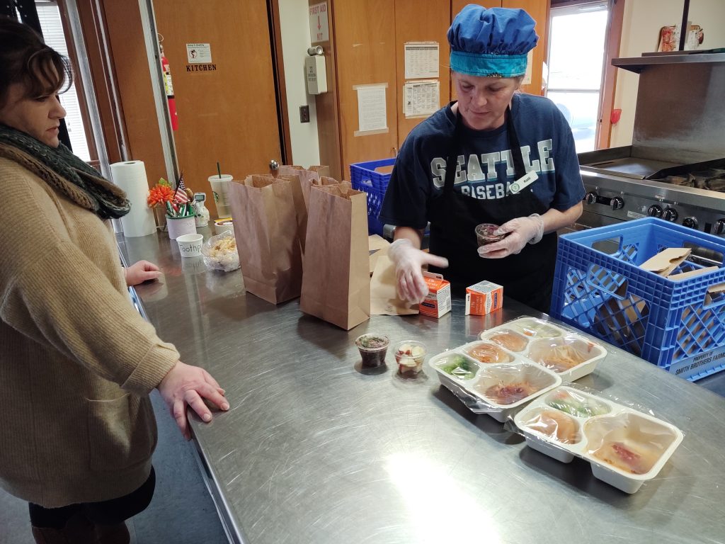 Ferndale Senior Activity Center Director Karma Wells awaits lunches being prepared by Center Cook Kelli Nopson (March 12, 2020). Photo: My Ferndale News
