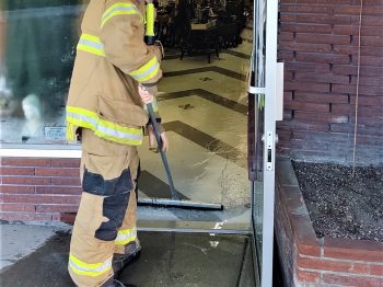 WCFD7 firefighters work to sweep water out of a downtown business after a hose broke in a bathroom (March 18, 2020). Photo: My Ferndale News