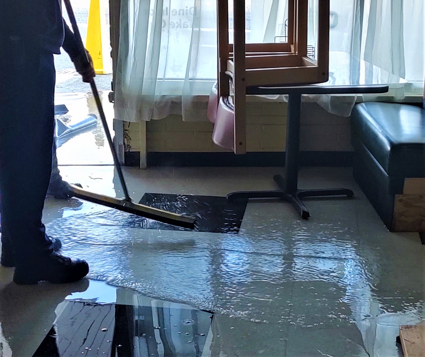 WCFD7 firefighters work to sweep water out of a downtown business after a hose broke in a bathroom (March 18, 2020). Photo: My Ferndale News