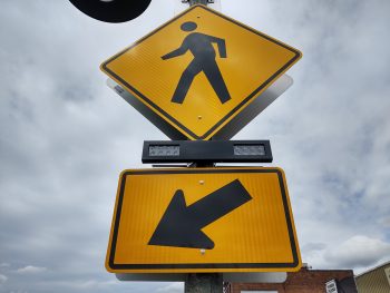Signs with a rectangular rapid flash beacon (RRFB) mounted on a light pole at 1st Avenue and Main Street (April 24, 2020). Photo: Whatcom News