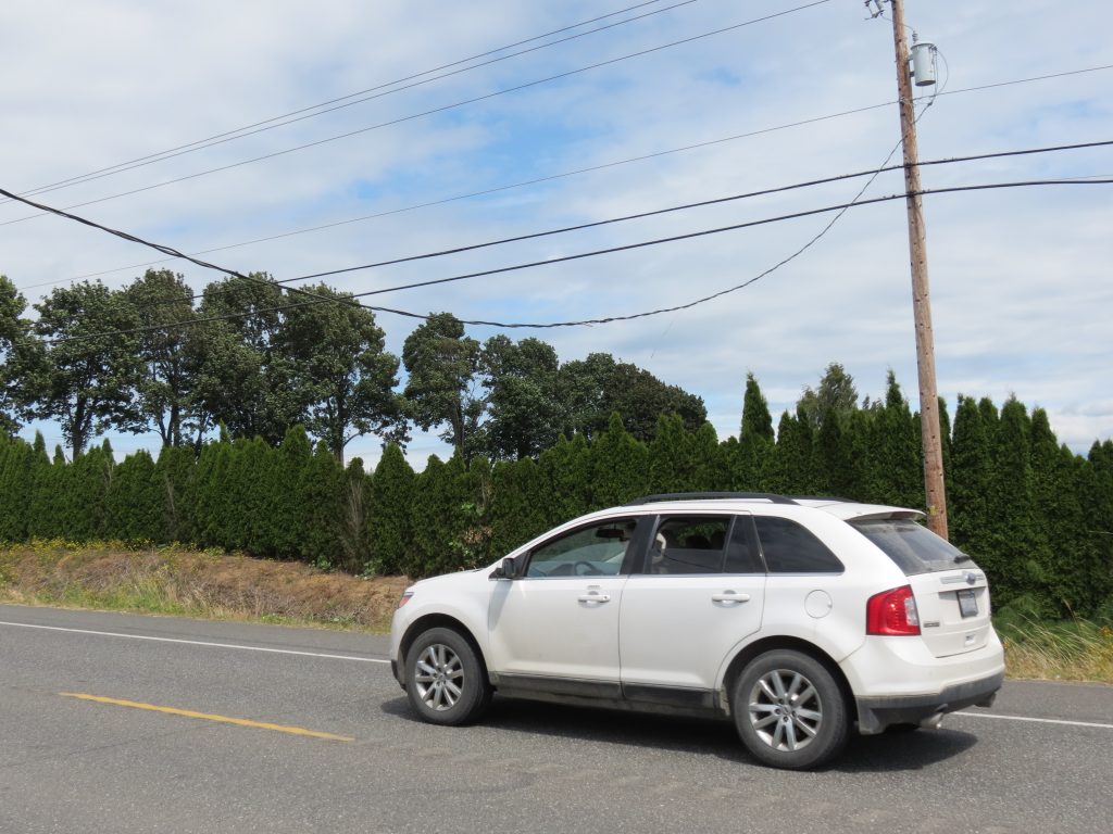 A SUV passes under a low power line over Northwest Drive while law enforcement prevented tall vehicles from becoming entangled while awaiting repairs (July 23, 2020). Photo: My Ferndale News
