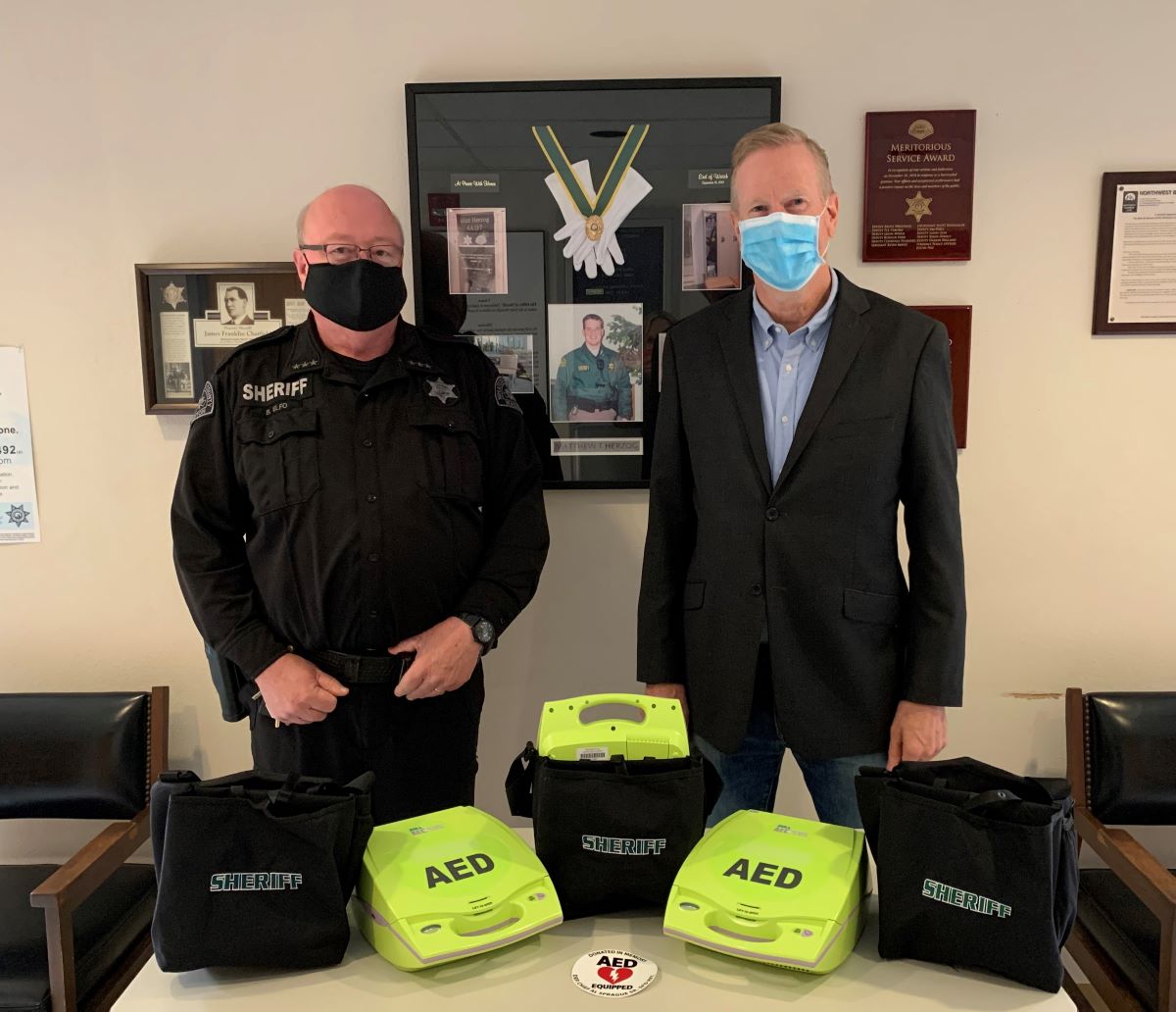 Sheriff Bill Elfo and Byron Sprague pose with some of the AEDs Sprague donated to WCSO (September 17, 2020). Photo courtesy WCSO