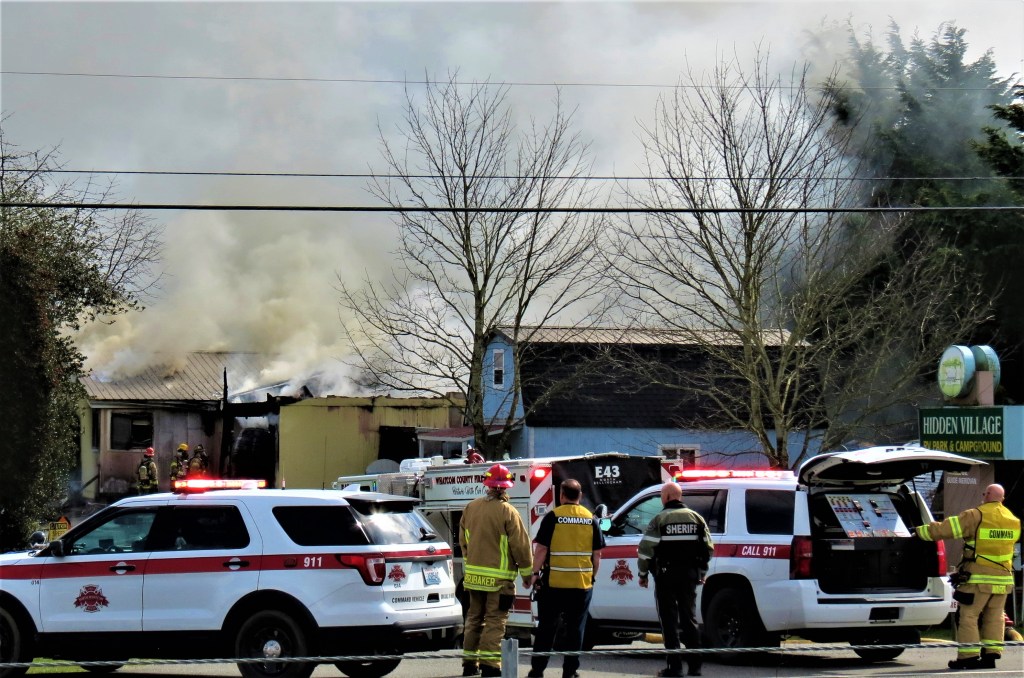 North Whatcom Fire and Rescue Division Chief Shaun Ward and others look on from the command post during a residential fire (March 30, 2021). Photo: Whatcom News