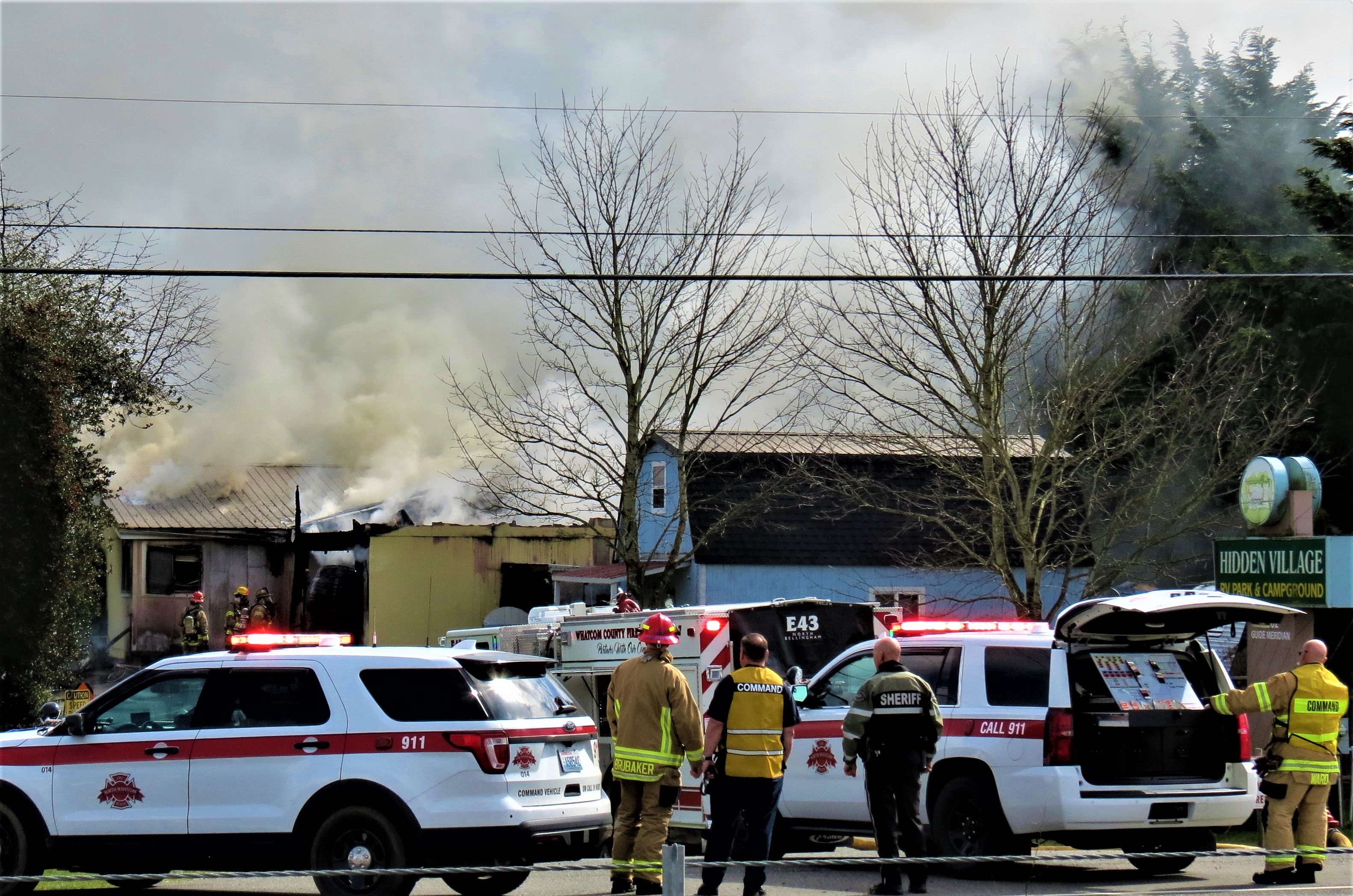 North Whatcom Fire and Rescue Division Chief Shaun Ward and others look on from the command post during a residential fire (March 30, 2021). Photo: Whatcom News