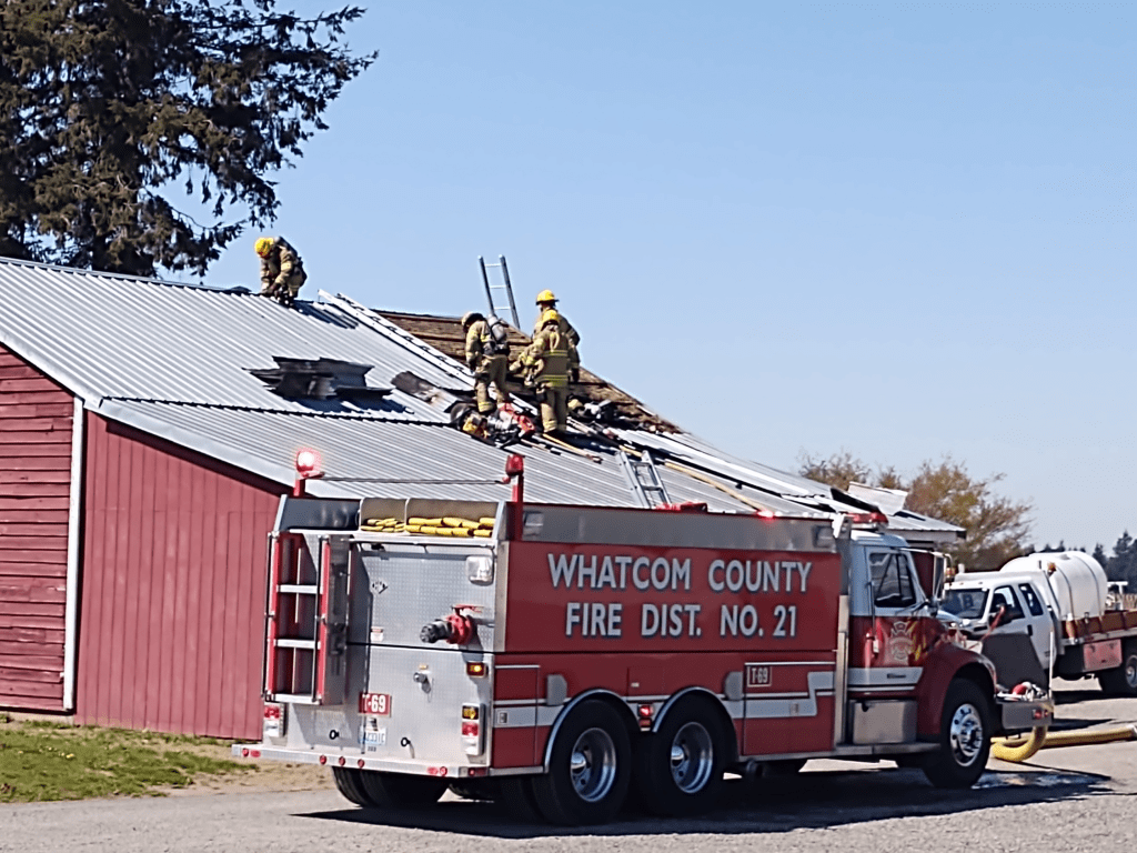 Firefighters removing roofing on a structure after extinguishing an interior fire (April 16, 2021). Photo: Whatcom News