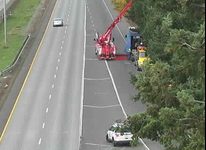 A tow truck can be seen working on clearing a disabled semi truck and trailer on an I-5 on-ramp (October 25, 2021). WSDOT traffic camera