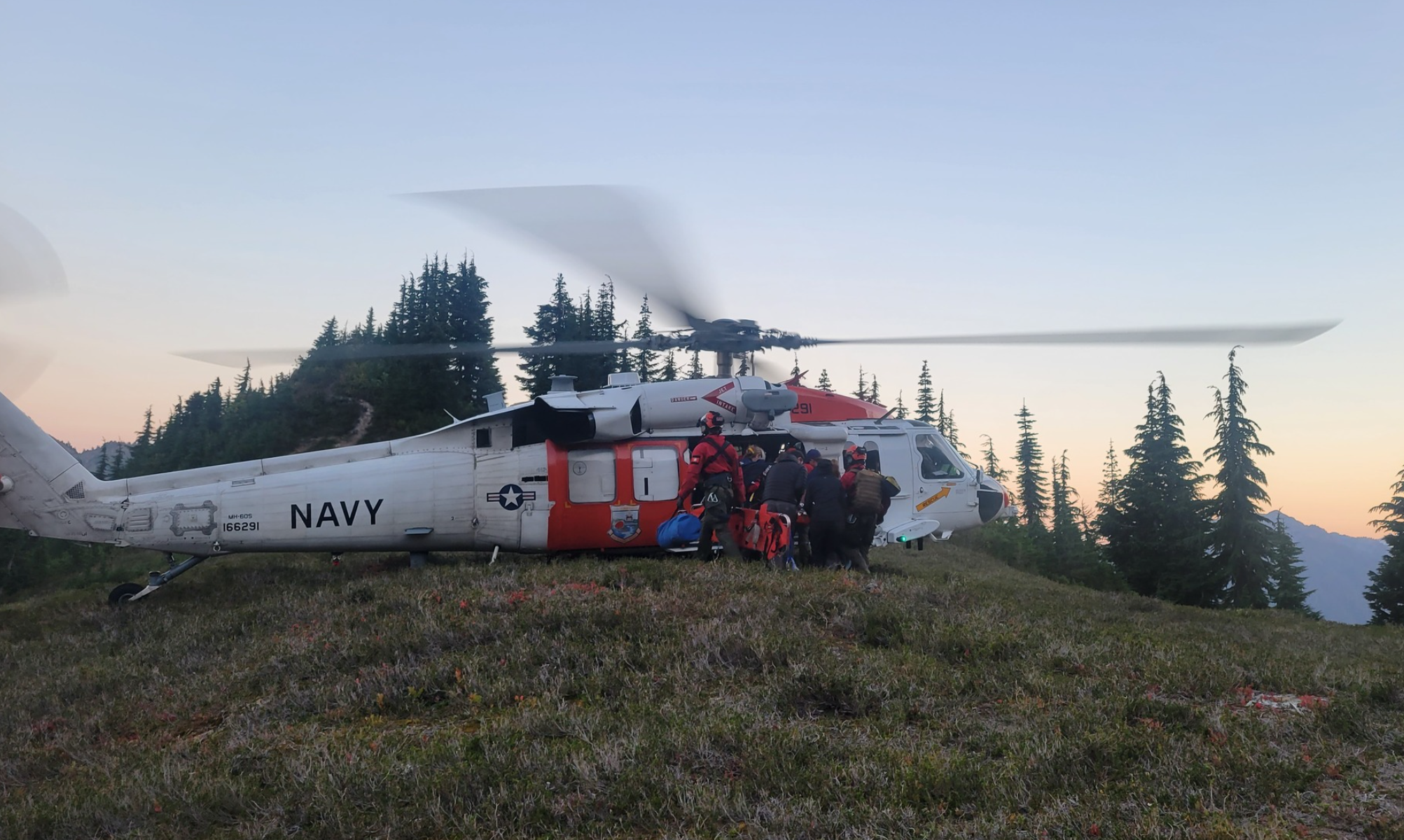 Rescuers assist with loading a hiker injured on the Yellow Aster Butte Trail into a Naval Air Station Whidbey Island helicopter to be transported to a hospital (September 19, 2022). Photo courtesy of WCFD14