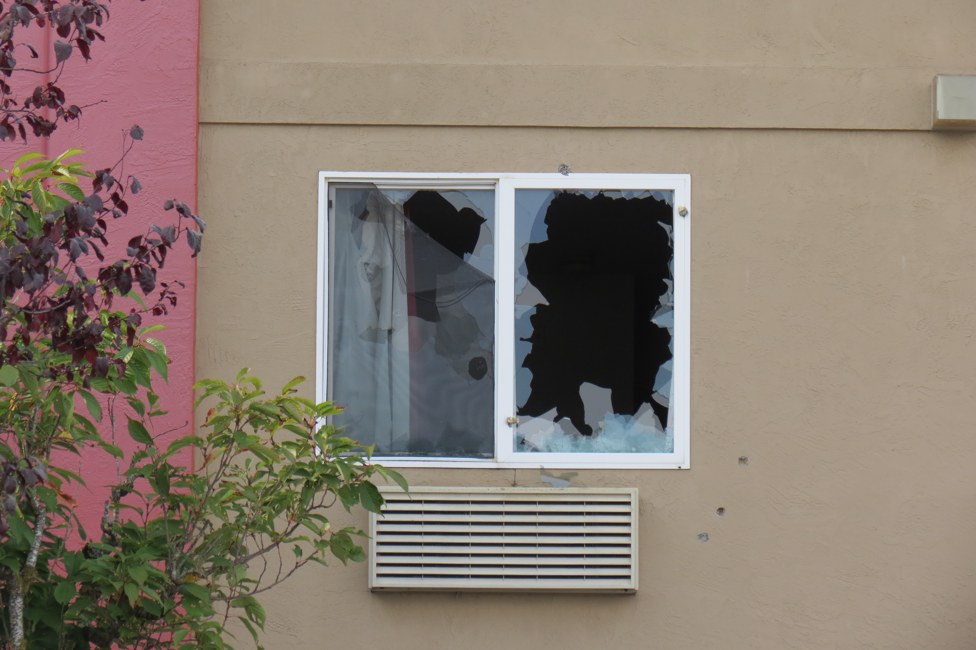 Broken glass and torn screen are visible from the parking lot after SWAT used tear gas to gain complaince from a man holed up in a Ferndale hotel (October 4, 2022). Photo: Whatcom News