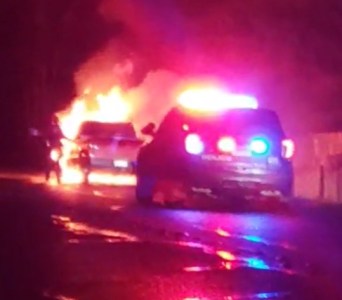 Bellingham Police officer seen attempting to access the passenger compartment of a burning pickup truck on E Bakerview Road (January 12, 2023). Photo courtesy of a reader