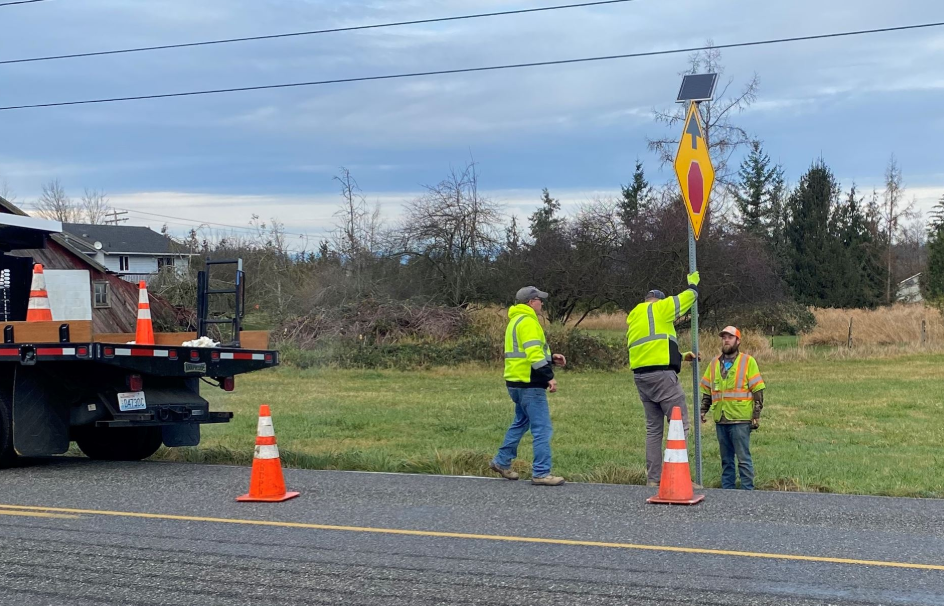 A Whatcom County Public Works crew installs flashing LED stop signs on S Pass Road at Goodwin Road. Source: WCPW
