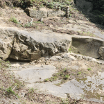 A large, loose rock on the slope above northbound I-5 south of Bellingham that will require closing southbound lanes temporarily in case debris would reach those lanes. (2026). Source: WSDOT