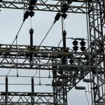 high voltage power lines against cloudy sky