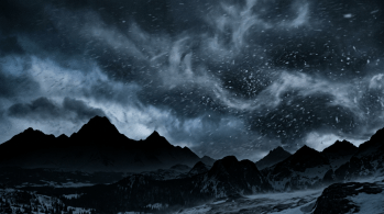 Dark mountain silhouette beneath a stormy night sky with swirling snowflakes